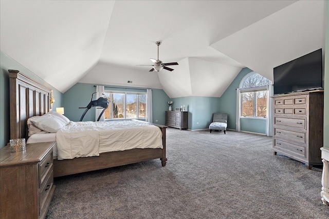 bedroom with multiple windows, dark carpet, vaulted ceiling, and ceiling fan