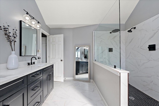 bathroom featuring vanity, vaulted ceiling, and a tile shower