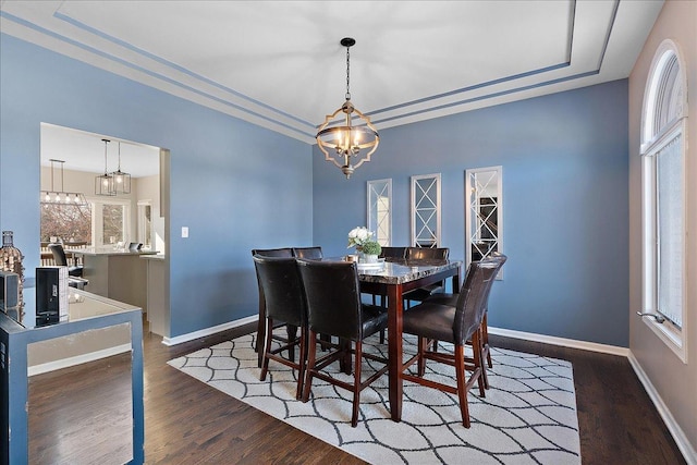 dining room featuring dark hardwood / wood-style flooring, a healthy amount of sunlight, and a chandelier