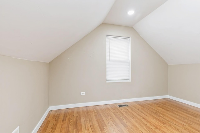 additional living space featuring wood-type flooring and lofted ceiling