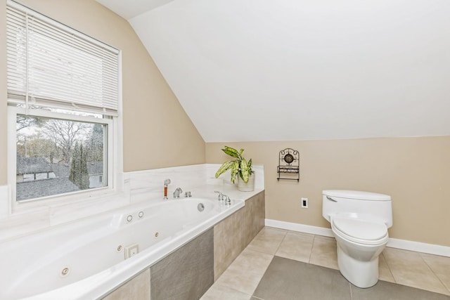 bathroom with tile patterned flooring, a relaxing tiled tub, toilet, and vaulted ceiling