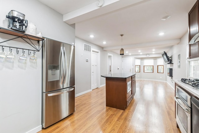 kitchen featuring dark brown cabinetry, hanging light fixtures, light hardwood / wood-style floors, a kitchen island, and appliances with stainless steel finishes