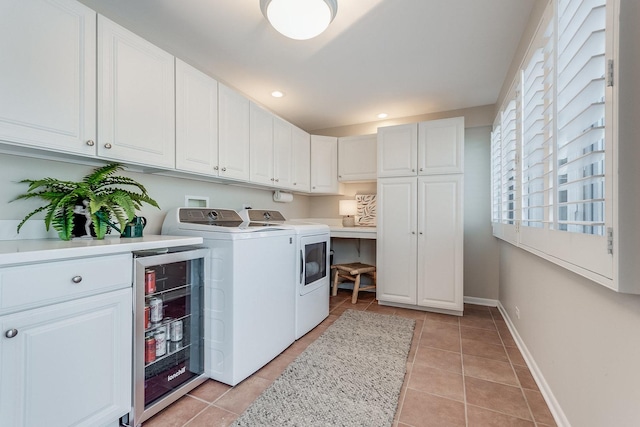 clothes washing area with wine cooler, light tile patterned floors, separate washer and dryer, and cabinets