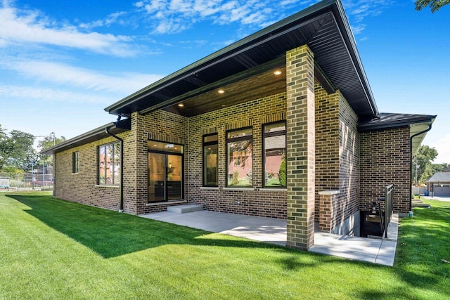 back of house with a yard and a patio