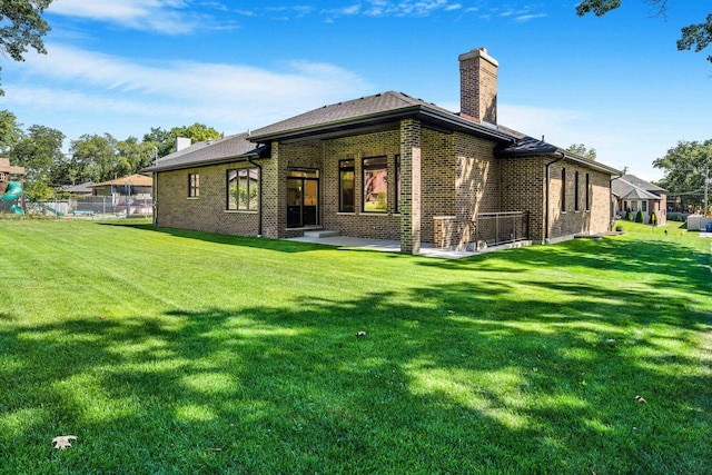 rear view of property featuring a lawn