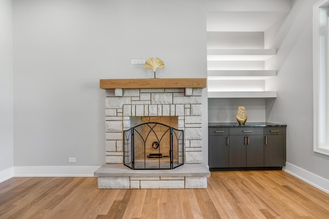 room details with hardwood / wood-style flooring and a stone fireplace