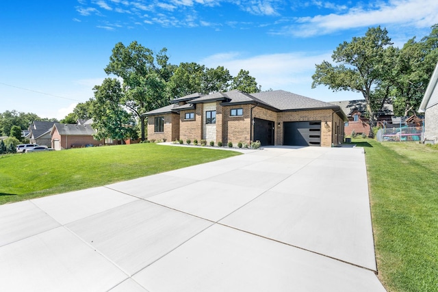 prairie-style house featuring a front lawn and a garage