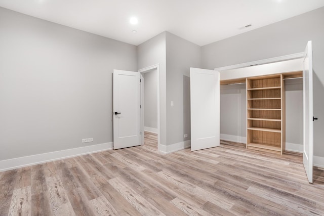 unfurnished bedroom with a closet and light hardwood / wood-style floors