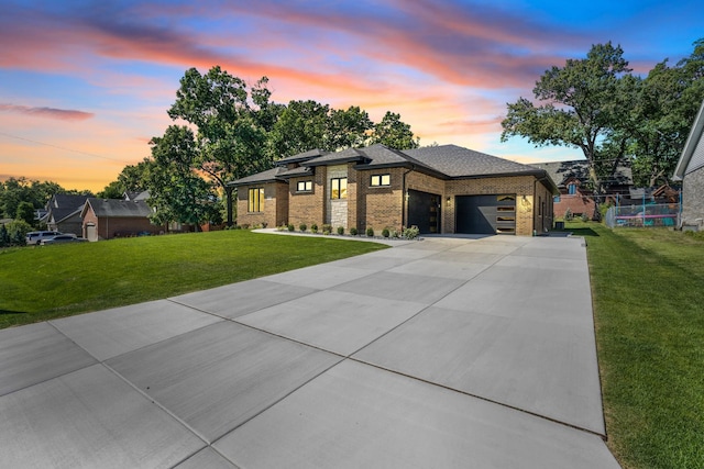 prairie-style home with a yard and a garage