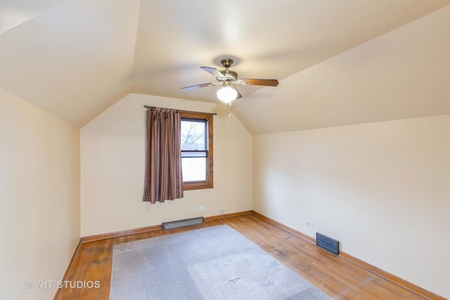 bonus room featuring lofted ceiling, a baseboard heating unit, light hardwood / wood-style floors, and ceiling fan