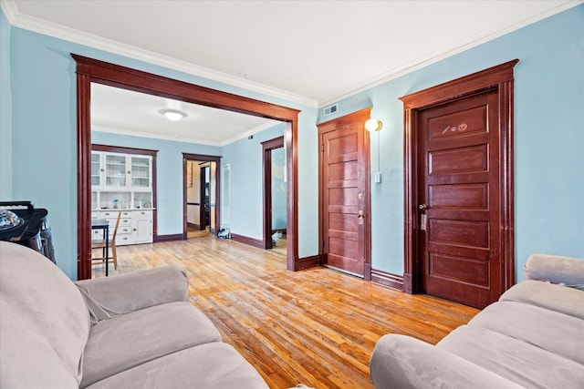 living room featuring ornamental molding and light wood-type flooring