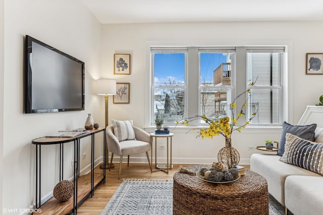 living area with a wealth of natural light and light hardwood / wood-style floors