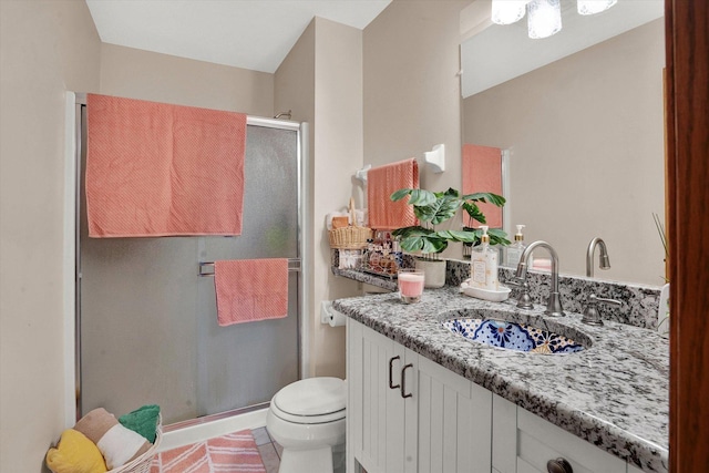 bathroom featuring tile patterned floors, vanity, toilet, and walk in shower