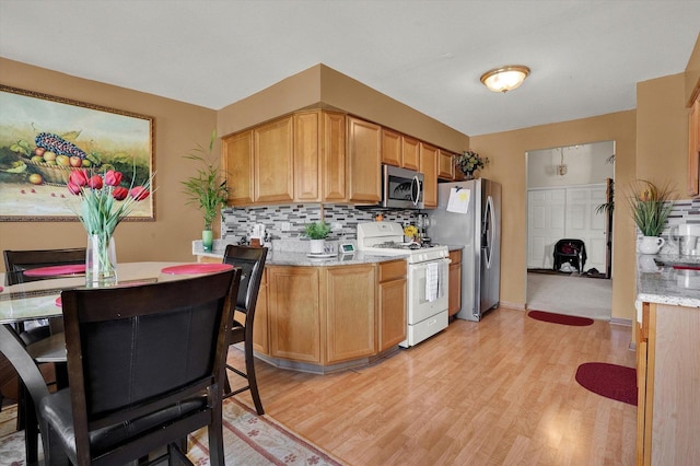 kitchen featuring backsplash, light hardwood / wood-style flooring, and stainless steel appliances