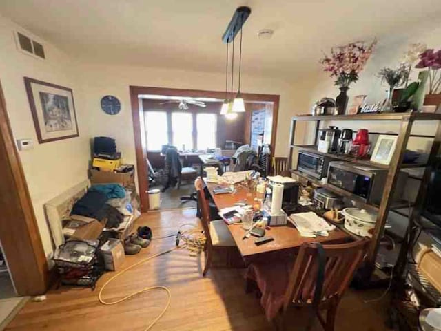 dining area with hardwood / wood-style floors and ceiling fan