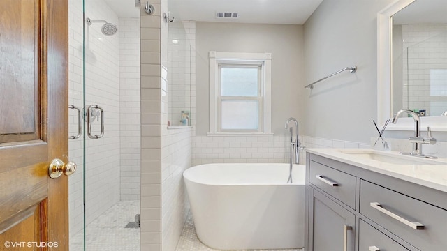 bathroom with shower with separate bathtub and vanity