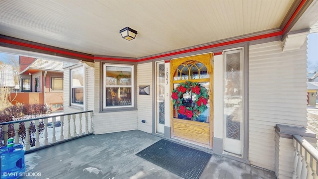 view of exterior entry featuring covered porch