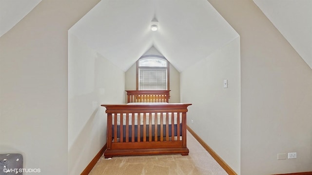 bedroom with light colored carpet and lofted ceiling