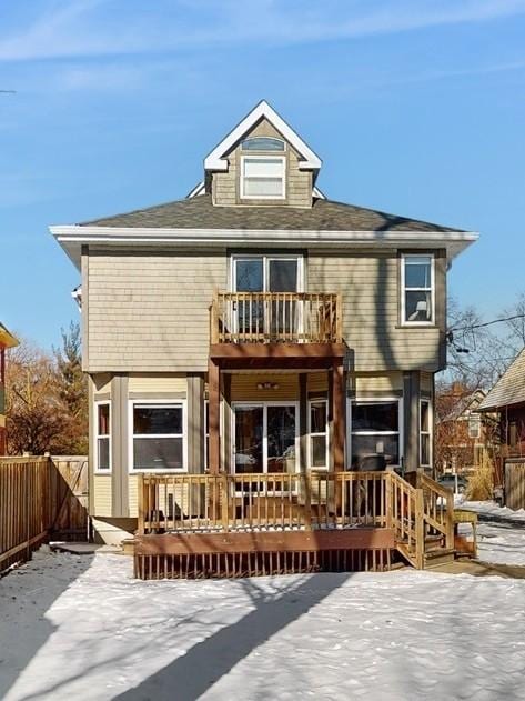 snow covered rear of property featuring a wooden deck