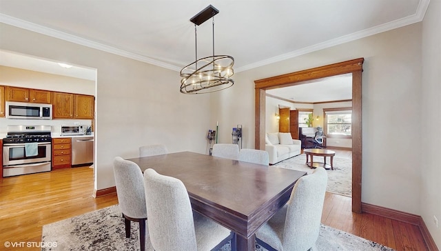 dining area featuring a chandelier, light hardwood / wood-style floors, and ornamental molding