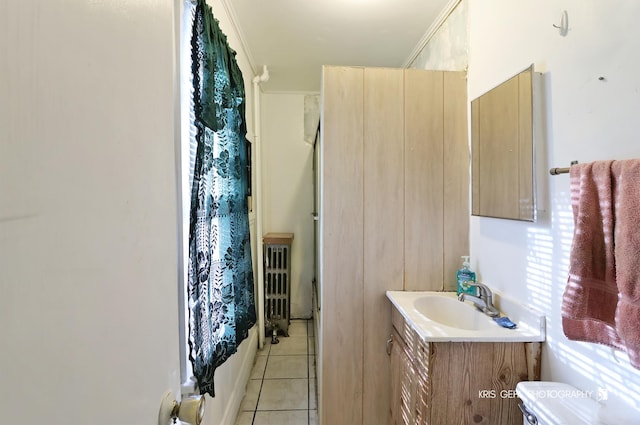 bathroom with radiator, tile patterned flooring, toilet, vanity, and ornamental molding