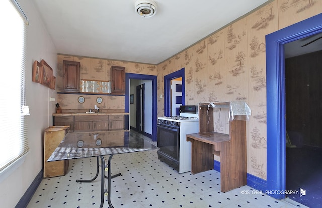 kitchen with white gas range and sink