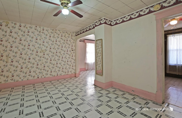 spare room with ceiling fan and plenty of natural light