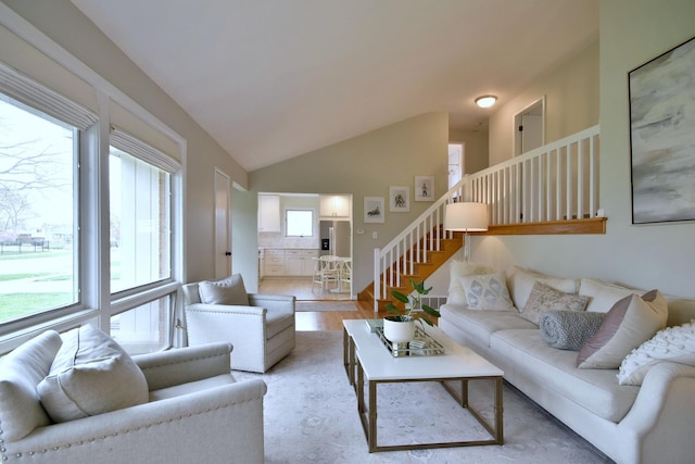 living room featuring lofted ceiling and light wood-type flooring