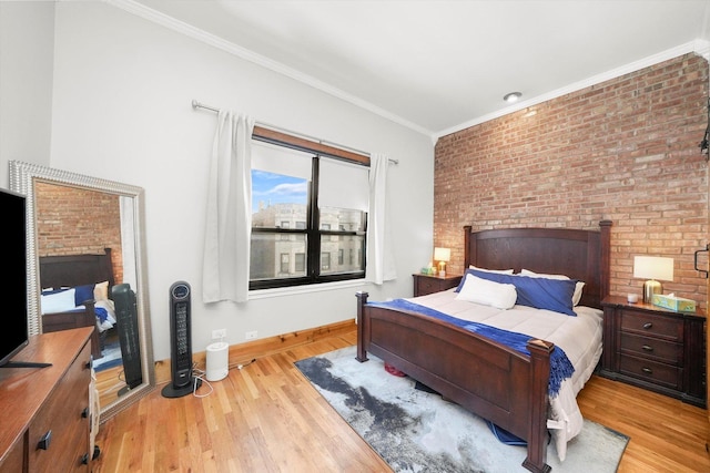 bedroom with crown molding, brick wall, and light hardwood / wood-style floors