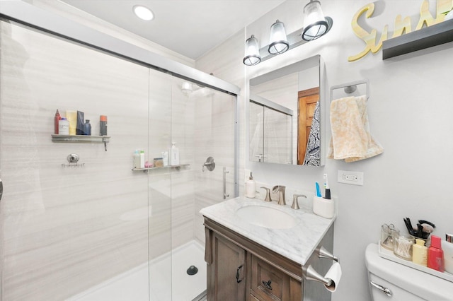 bathroom featuring vanity, a shower with shower door, and toilet