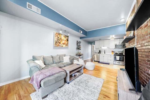 living room with sink and light hardwood / wood-style floors