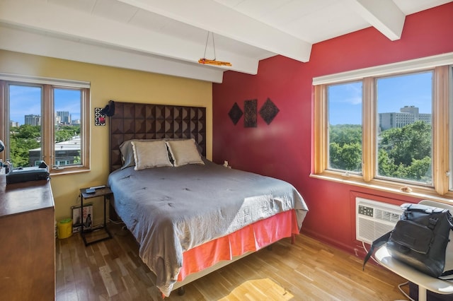 bedroom with beamed ceiling and hardwood / wood-style floors