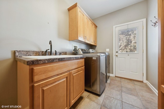 washroom with washing machine and clothes dryer, sink, and cabinets