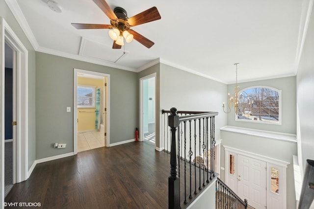 hallway with a notable chandelier, dark hardwood / wood-style flooring, and ornamental molding