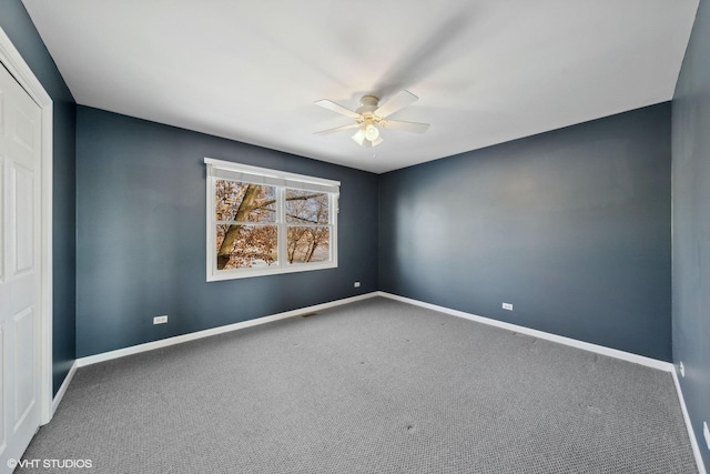 carpeted spare room with ceiling fan