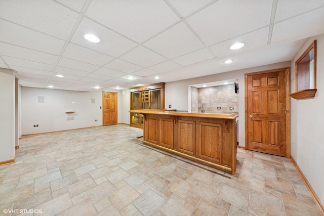 bar featuring a drop ceiling and sink