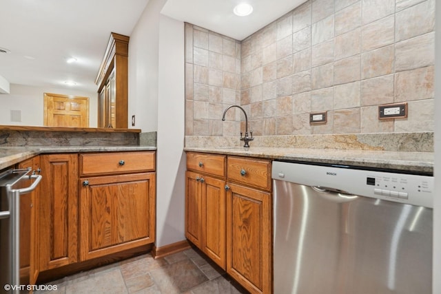 kitchen with dishwasher, tasteful backsplash, light stone countertops, and sink