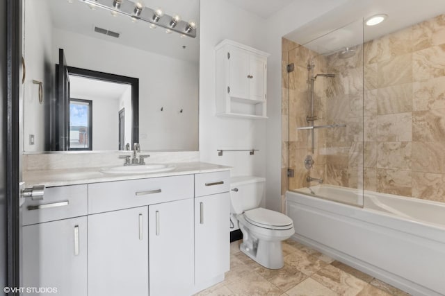 full bathroom featuring toilet, vanity, and bath / shower combo with glass door