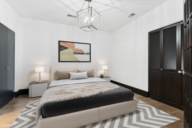 bedroom featuring a notable chandelier, light hardwood / wood-style flooring, and a closet