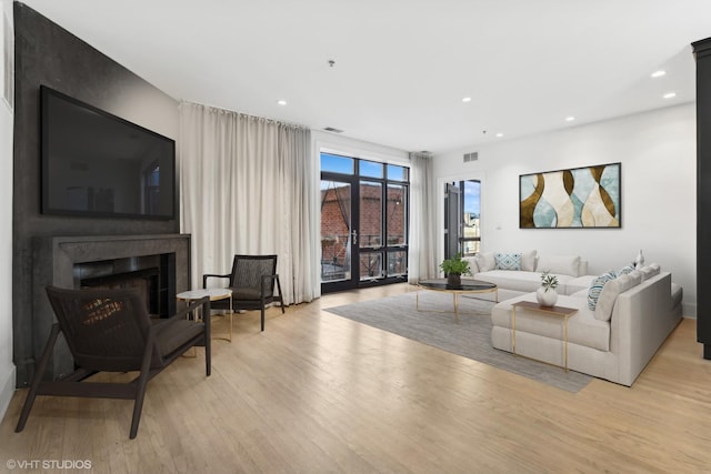 living room with a fireplace and light hardwood / wood-style flooring