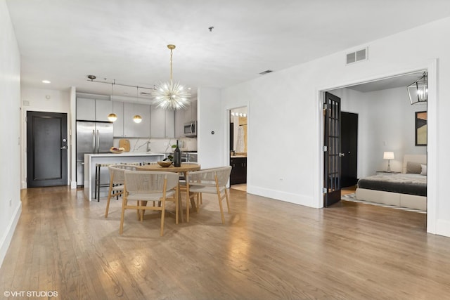 dining room featuring a chandelier and light hardwood / wood-style flooring