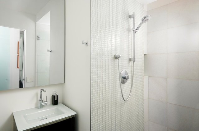 bathroom with vanity and tiled shower