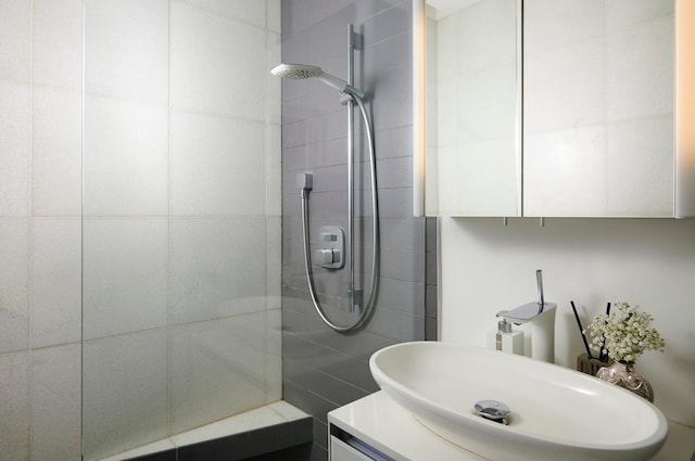 bathroom featuring a tile shower and vanity