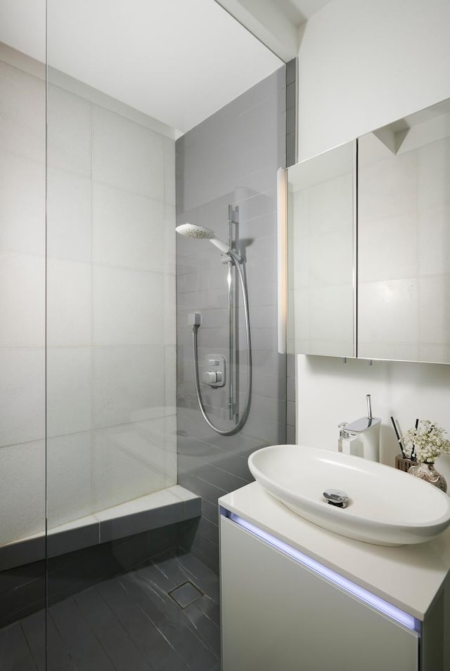 bathroom with vanity and tiled shower