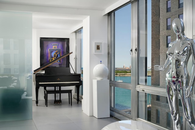 interior space featuring a baseboard heating unit, light tile patterned floors, and a water view