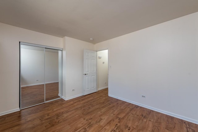 unfurnished bedroom featuring wood-type flooring and a closet