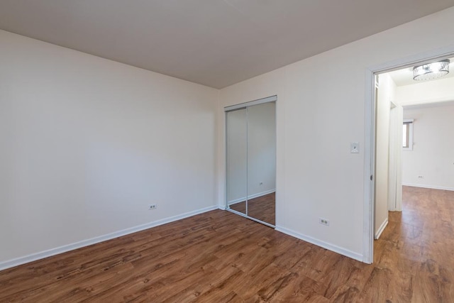 unfurnished bedroom featuring dark wood-type flooring and a closet