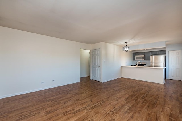 unfurnished living room with dark wood-type flooring and a chandelier