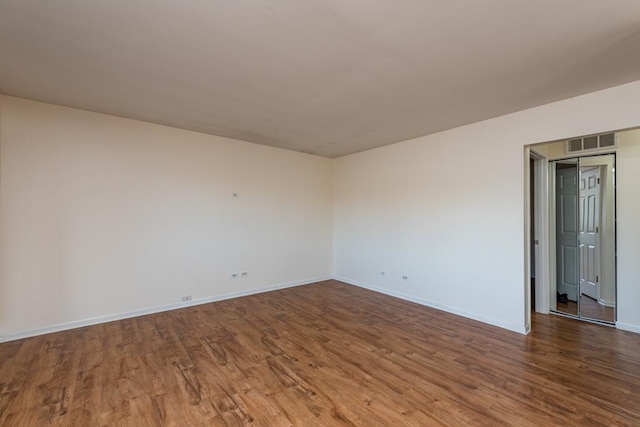 empty room with hardwood / wood-style flooring