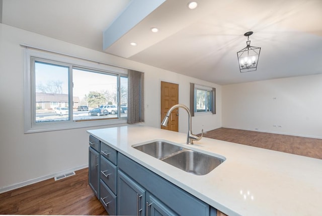 kitchen featuring pendant lighting, dark hardwood / wood-style floors, sink, and a notable chandelier